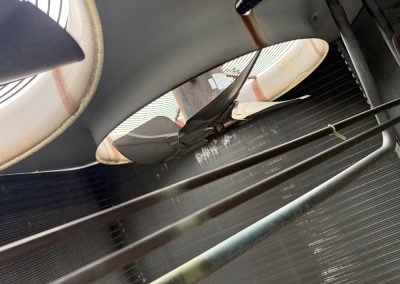Close-up view of an outdoor HVAC unit fan and condenser coils.