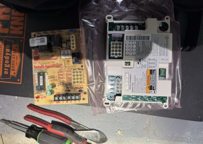 Two White-Rodgers furnace control boards, one inside a plastic bag, with pliers and a screwdriver below.
