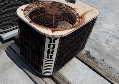 York and Bryant air conditioning units on a flat roof with a cordless drill resting on the York unit.