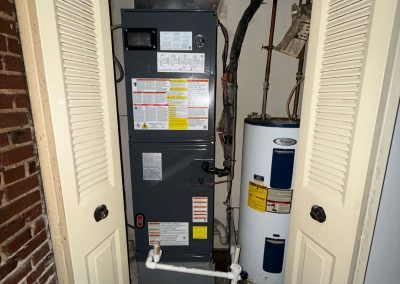 A furnace and a water heater located inside a closet.