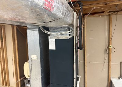 HVAC unit and ductwork in an unfinished basement.